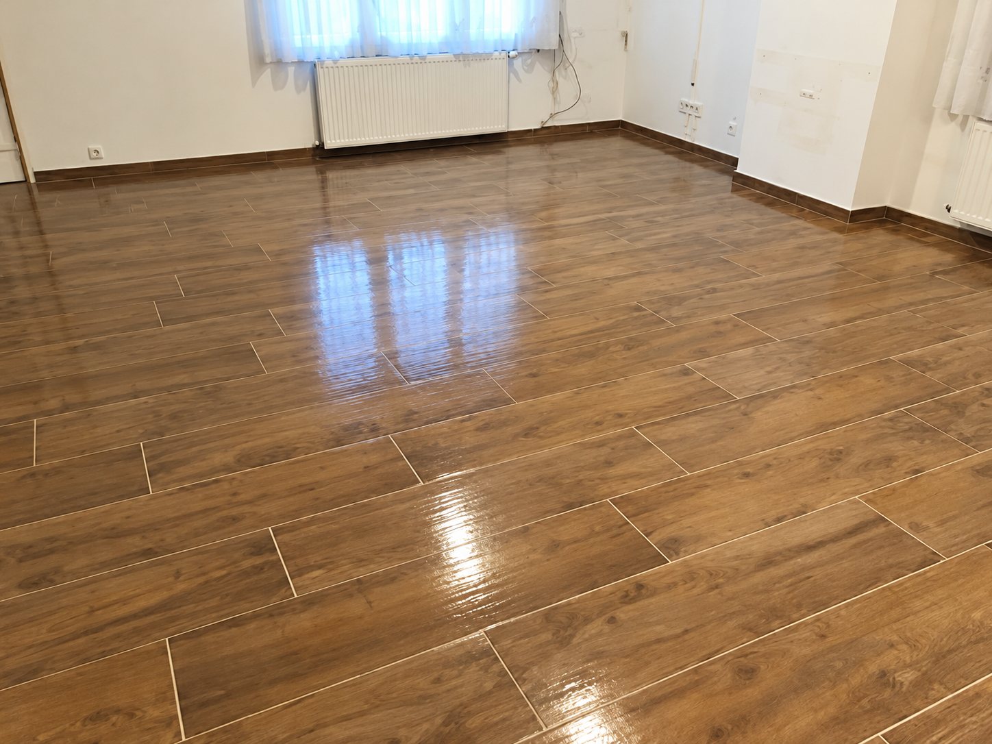 Sol carrelé imitation parquet brillant dans une pièce rénovée
